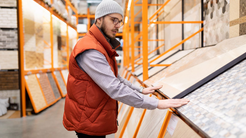 A man in a decorating store chooses flooring option