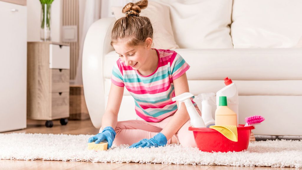 Girl brushing carpet to remove stains