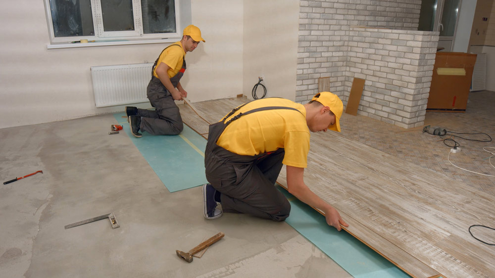 Men laying new laminate flooring