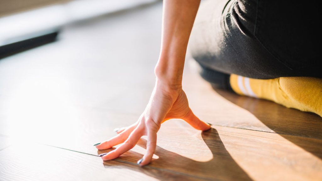 Woman hand touching even laminated floor