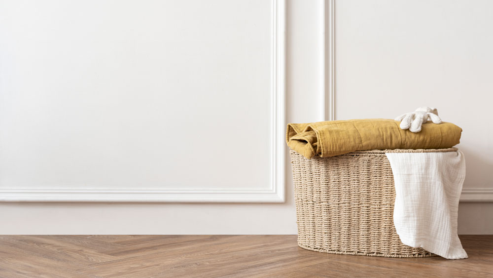 Laundry basket in a white room with timber flooring