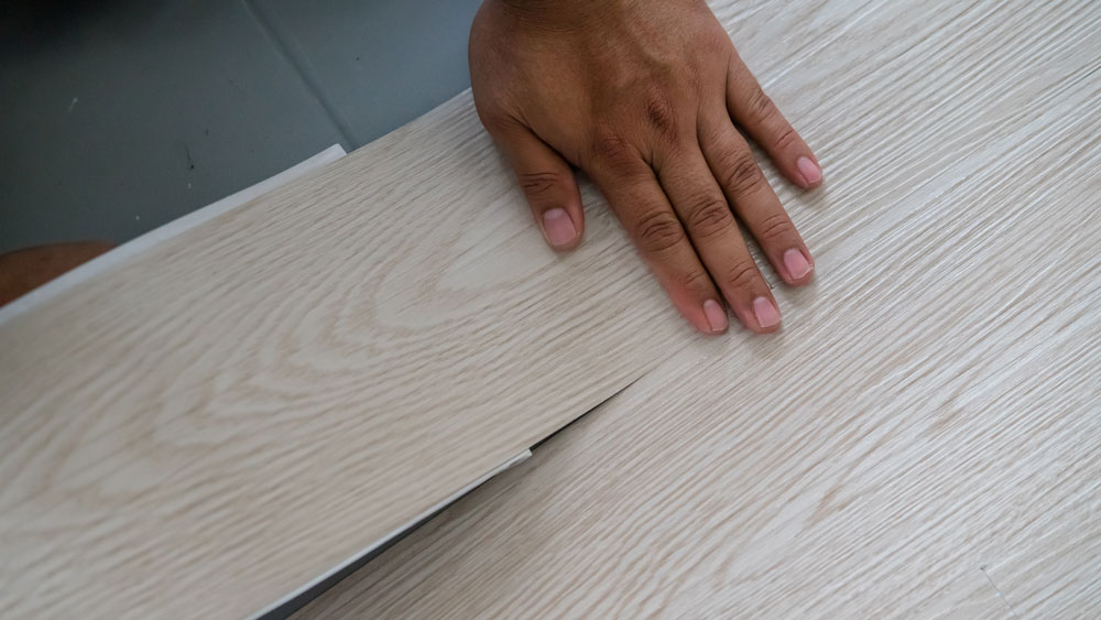 A man installing vinyl flooring