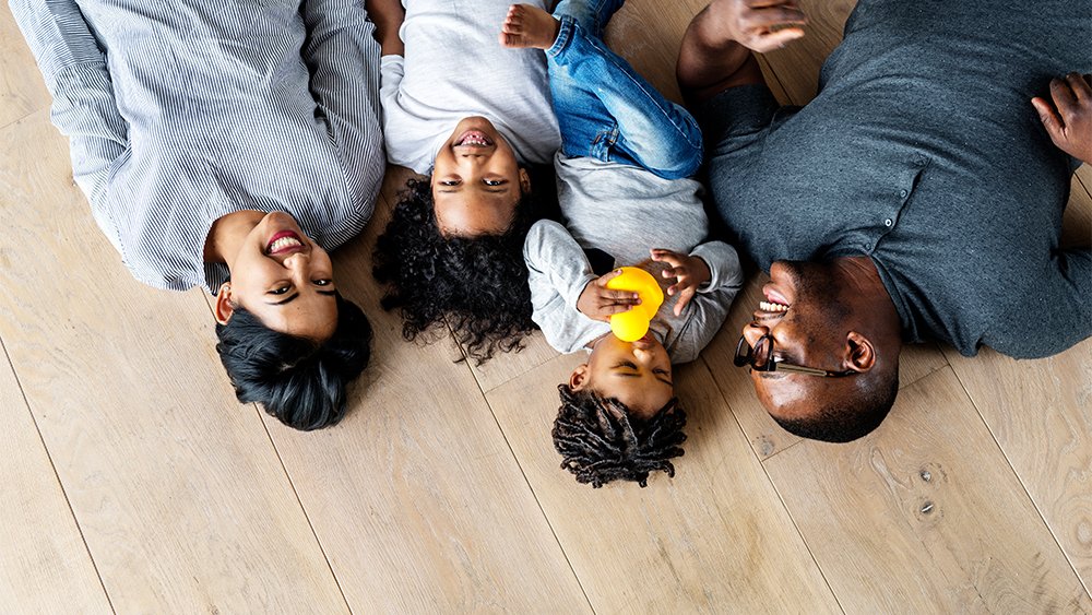 Happy family laid down on laminate flooring