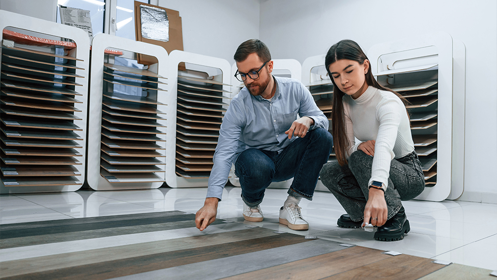 Young couple selecting among laminate flooring patterns and colors