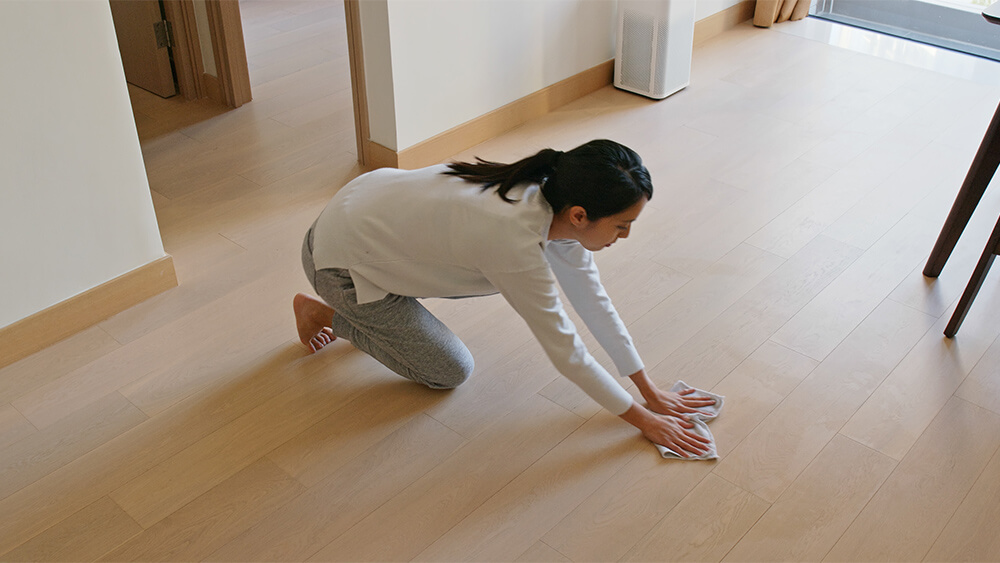 Asian woman cleaning laminate floor