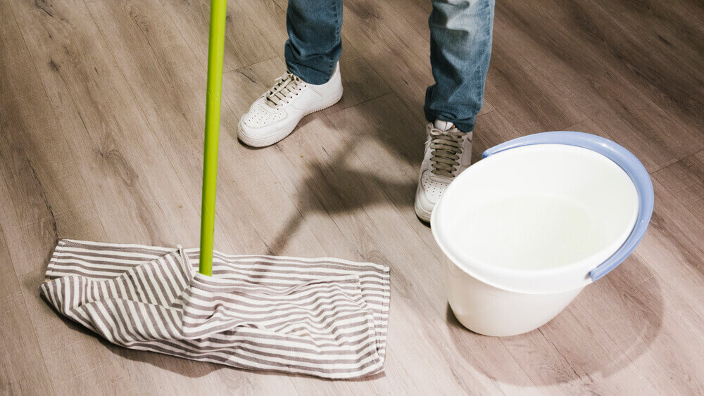 Close up of a man mopping a laminate floor