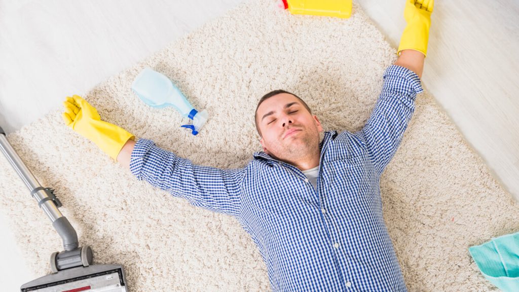 Man is tired from cleaning carpet