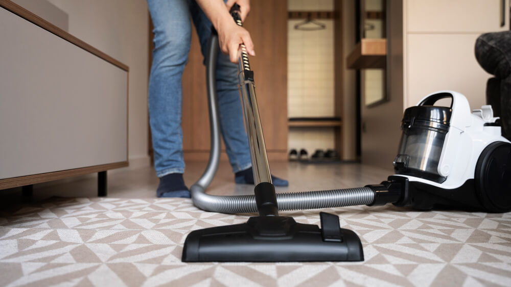 Man vacuuming a carpet