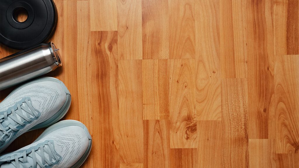 Woman with running shoes water bottle standing on laminate floor