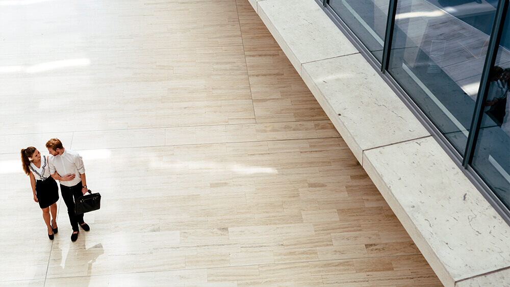 A couple walking in a commercial area with laminate flooring