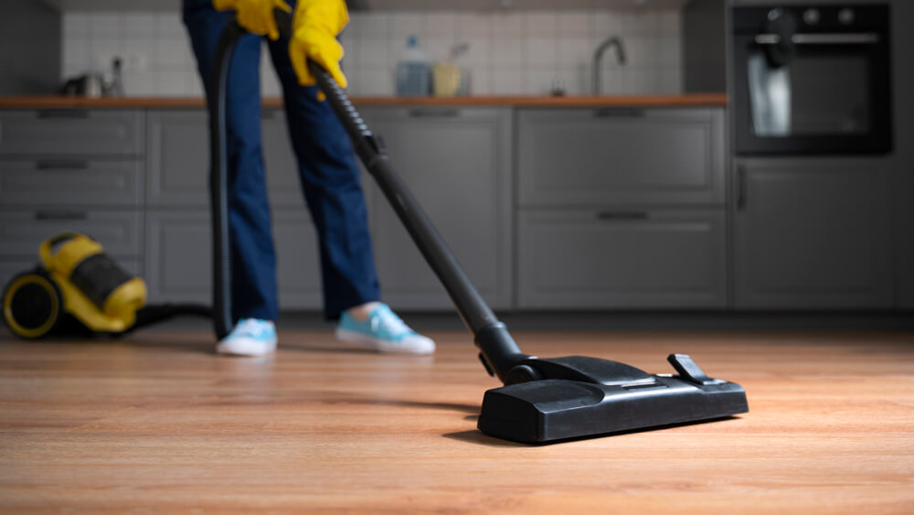 Front view of a woman vacuuming flooring