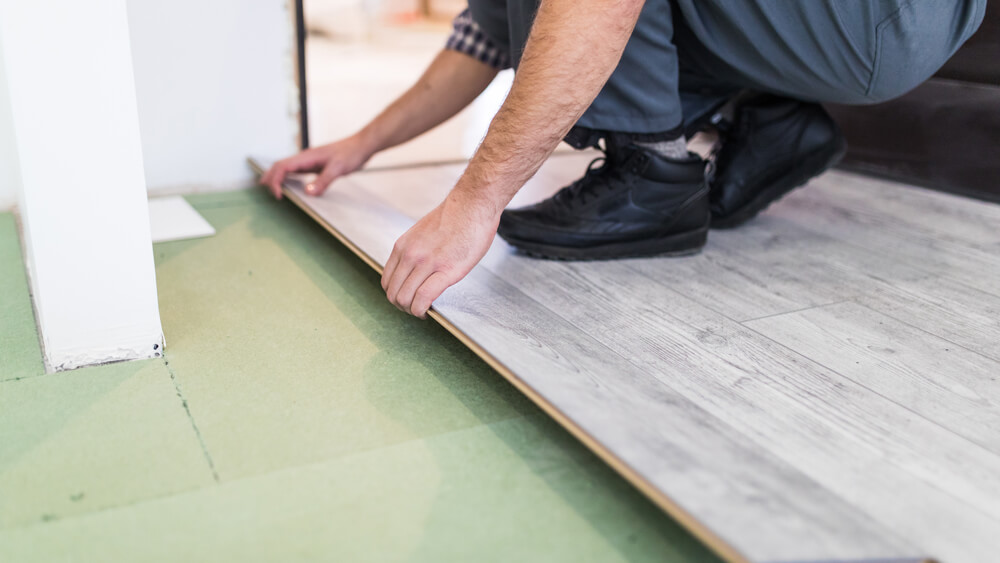 Worker processing floor with laminated flooring boards