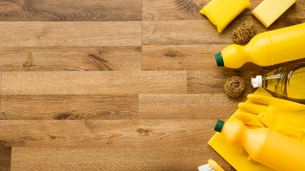 Different cleaning tools and products on bamboo flooring