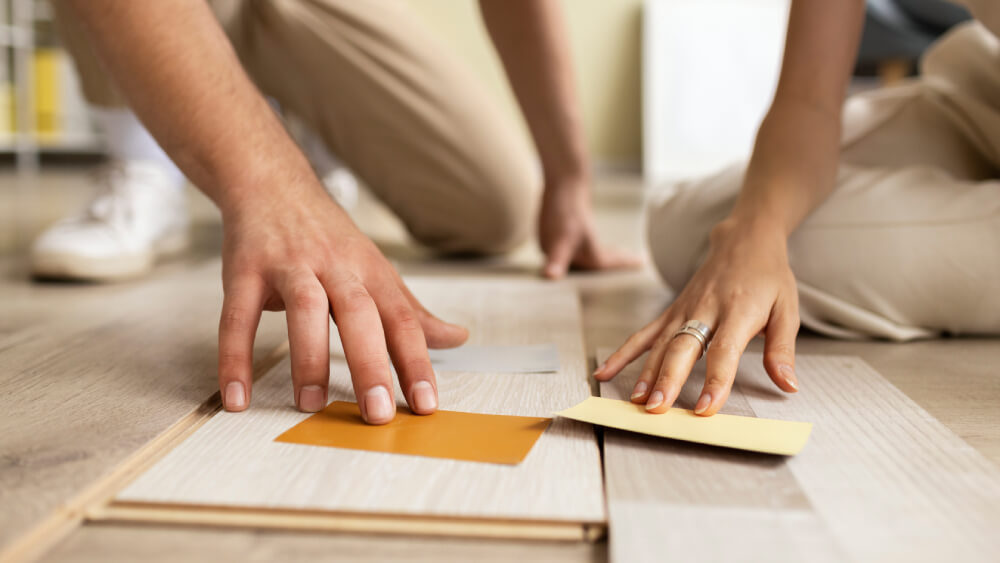 Two people measuring laminate pieces before installation