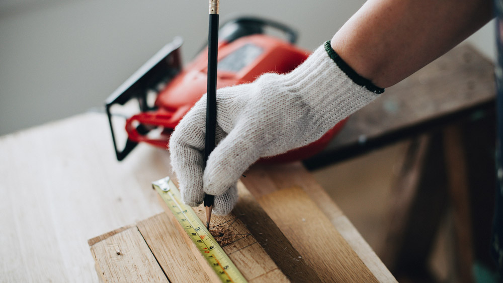 Woman measuring wooden plank