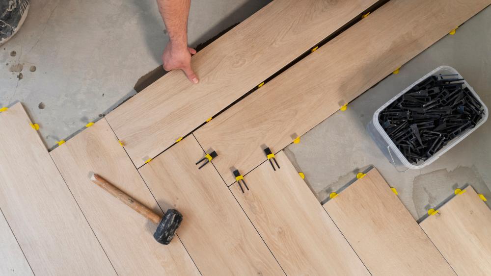 Top view of a man installing laminate flooring